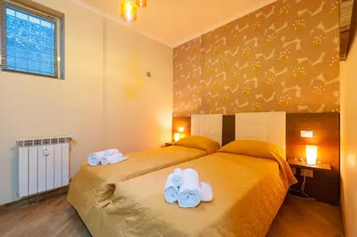 a bedroom with two beds with white towels on them at Nostalgia Romana in Rome