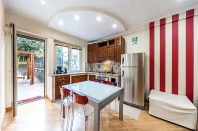 a kitchen with a table and a refrigerator at Nostalgia Romana in Rome