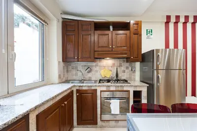 a kitchen with wooden cabinets and a stainless steel refrigerator at Nostalgia Romana in Rome