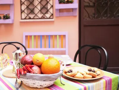 a table with a bowl of fruit and vegetables on it at Pisetzky-Spadaro Apartments - Vegezio Roma in Rome
