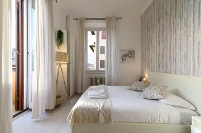 a bedroom with a white bed and a window at White Napoleone Apartment in Rome