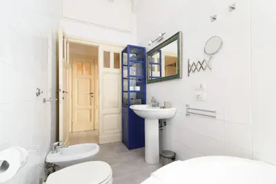 a bathroom with two toilets and a sink and a mirror at White Napoleone Apartment in Rome
