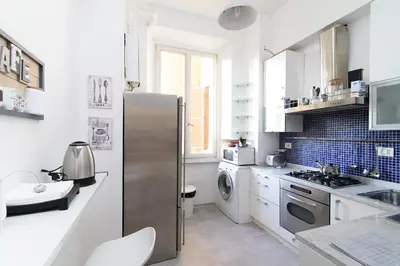 a kitchen with a stainless steel refrigerator and a sink at White Napoleone Apartment in Rome