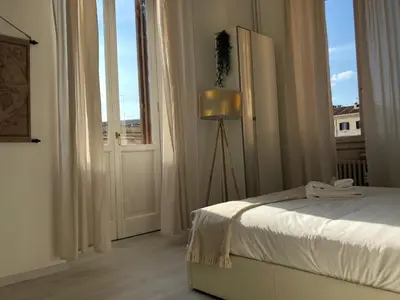 a bedroom with a bed and a large window at White Napoleone Apartment in Rome