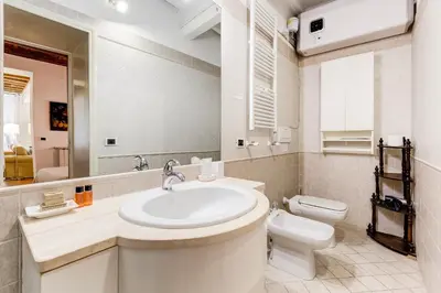 a white bathroom with a sink and a toilet at Diana-Spanish Steps House in Rome