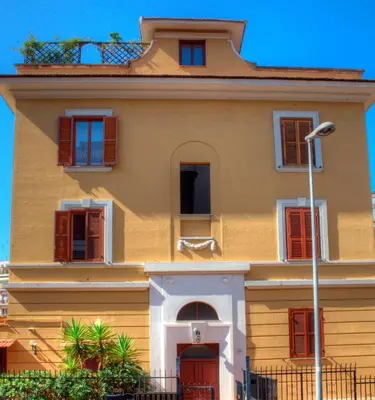 a yellow building with red shutters on it at Bed and Breakfast 30 in Rome
