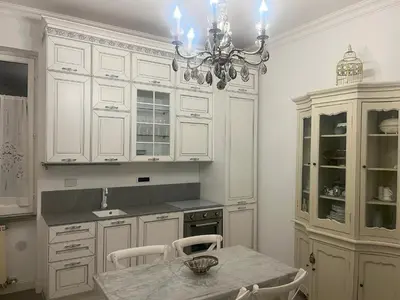 a kitchen with white cabinets and a table and a chandelier at Bed and Breakfast 30 in Rome