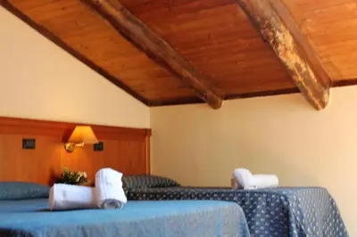 a bedroom with two beds and a wooden ceiling at Nights In Rome in Rome