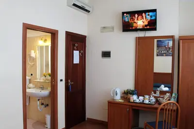a bathroom with a sink and a toilet and a tv on the wall at Nights In Rome in Rome