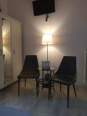 two chairs and a table in a room with a lamp at roma capoccia b&b in Rome