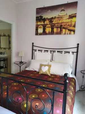 a bedroom with a bed with a painting on the wall at roma capoccia b&b in Rome