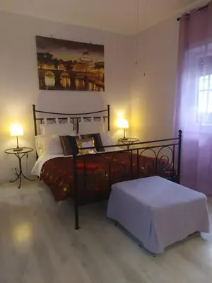 a bedroom with a bed and two tables with lamps at roma capoccia b&b in Rome