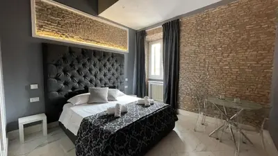 a bedroom with a large bed and a brick wall at Rhome Luxury suite in Rome