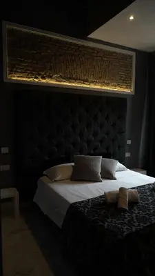 a bedroom with a large bed with a black headboard at Rhome Luxury suite in Rome