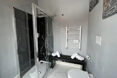 a bathroom with a glass shower and a toilet at Rhome Luxury suite in Rome