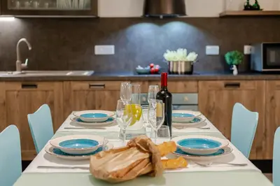 a table with a bottle of wine and blue plates and glasses at Casa Frisi in Rome