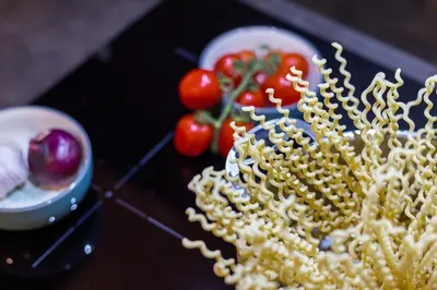 a plate of food with pasta and tomatoes on a table at Casa Frisi in Rome