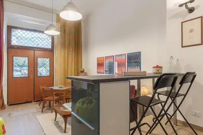 a kitchen with a counter and chairs in a room at GuestHost - Monti Artistic Flat in Rome