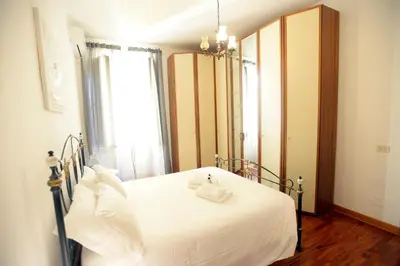 a bedroom with a white bed and a large mirror at MECENATE DELUXE COLOSSEUM in Rome