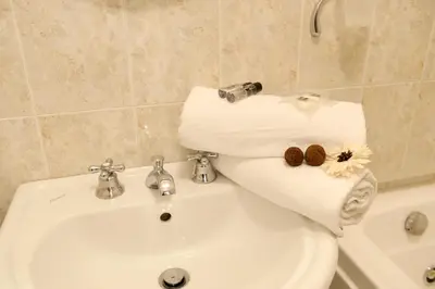 a bathroom with a toilet and a sink with towels at MECENATE DELUXE COLOSSEUM in Rome