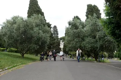 a group of people walking down a street in a park at MECENATE DELUXE COLOSSEUM in Rome