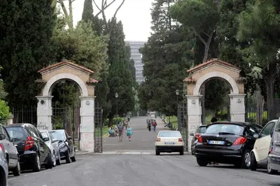 a street with cars parked in front of two archways at MECENATE DELUXE COLOSSEUM in Rome