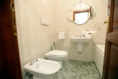 a bathroom with a toilet and a sink and a mirror at MECENATE DELUXE COLOSSEUM in Rome