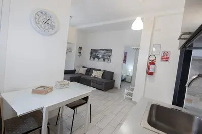 a kitchen and living room with a couch and a clock on the wall at Nicla's Home in Rome