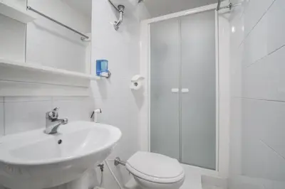 a white bathroom with a toilet and a shower at Vertex Homes in Rome