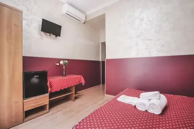 a hotel room with two beds and a flat screen tv at Vertex Homes in Rome