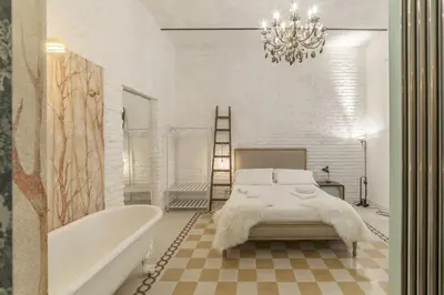 a bathroom with a bed and a bath tub and a chandelier at Romantic Vintage Colosseum Suite in Rome