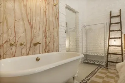 a white bath tub in a bathroom with a ladder at Romantic Vintage Colosseum Suite in Rome