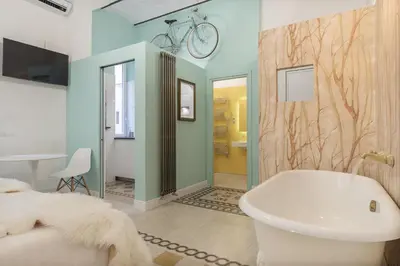 a bathroom with a bed and a tub and a sink at Romantic Vintage Colosseum Suite in Rome