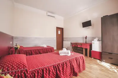 a hotel room with two beds and two tables at Vertex Guest House in Rome