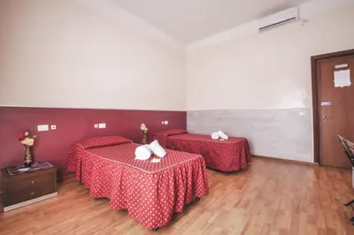 a hotel room with two beds and a tv at Vertex Guest House in Rome
