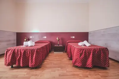 a room with two beds with red table cloths at Vertex Guest House in Rome