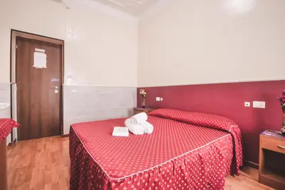 a bedroom with a red bed with two towels on it at Vertex Guest House in Rome