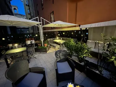 an outdoor patio with chairs and tables and umbrellas at Domus Flavia B&B in Rome