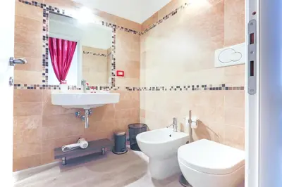 a bathroom with a toilet and a sink and a mirror at History Suite in Rome
