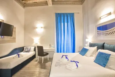 a hotel room with two beds and a window at History Suite in Rome