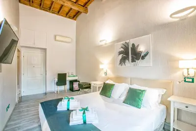 a bedroom with a bed with green and white pillows at History Suite in Rome