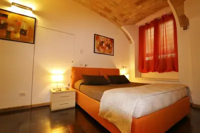 a bedroom with an orange bed and a window at Residenza Adriana in Rome