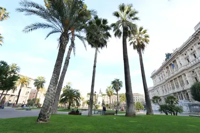a group of palm trees in front of a building at Residenza Adriana in Rome