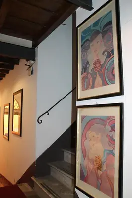 two paintings on the wall of a building with stairs at Relais Palazzo Taverna in Rome