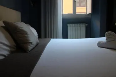 a bedroom with a bed with a pillow and a window at Relais Palazzo Taverna in Rome