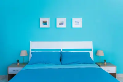 a blue bedroom with a large bed with blue walls at Quelli della via Gluck in Rome