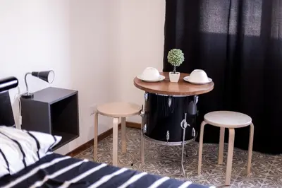 a small table with two stools in a bedroom at Quelli della via Gluck in Rome