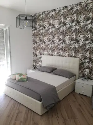 a bedroom with a large bed and a wall at Appia Garden in Rome
