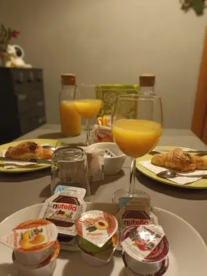 a table with a plate of food and a glass of orange juice at Double B in Rome