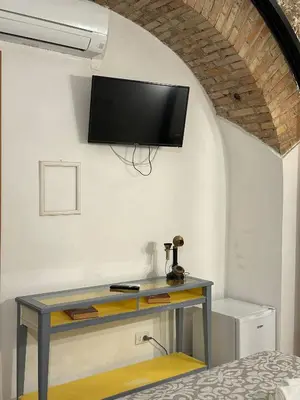 a room with a desk with a tv on the wall at Double B in Rome